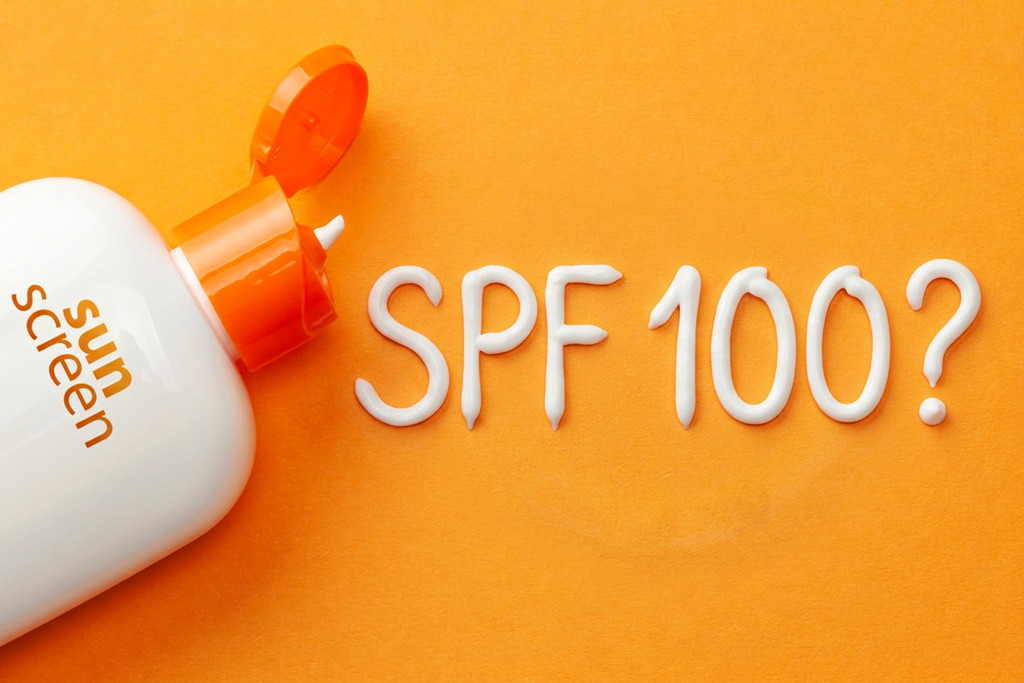 Sunscreen bottle with 'SPF 100?' written in sunscreen cream on an orange background.