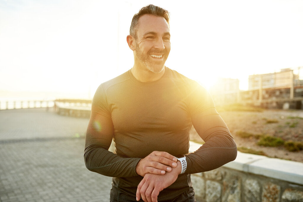 Man wearing a UPF shirt outdoors in bright sun, showing the importance of sun protection during peak UV hours